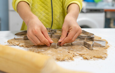 Child's hands cooking christmas cookies seen from close up