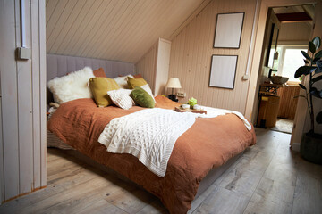 Modern bedroom interior, double bed with beige linen bedspread and colorful pillows