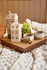 A serving tray with coffee cups and flowers stands on the bed in the bedroom