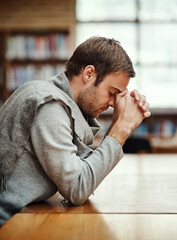 Fototapeta premium Man, praying and spiritual in university for study, worship and college scholarship in library. Student, faith and meditation to God on campus for school project, education and final exam or test