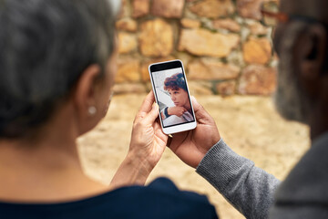 Senior couple, hands and phone with photo, memory and family update outdoor in a park. Retirement, backyard and mobile with social media, website and app scroll for picture and bonding together