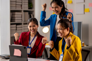 Three women are celebrating in a cubicle