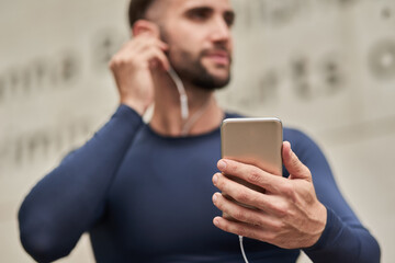 Man, fitness and phone with earphones for audio, music or listening to online subscription or...