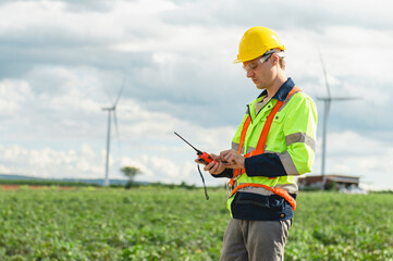 man in a yellow and orange safety vest is looking at a device