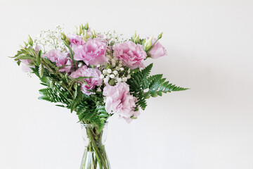 Bouquet Of Pink Lisianthus And Gypsophila Flowers Standing In A Glass Vase On A White Background