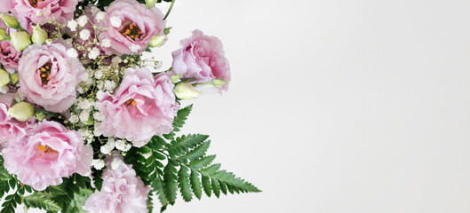 Bouquet Of Pink Lisianthus Flowers And Green Leaves Is Lying On The Left Side Of A White Background