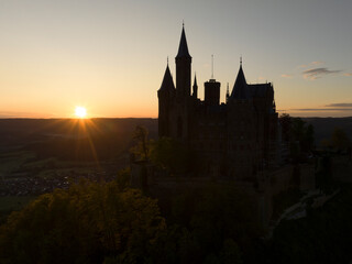Fototapeta premium Silhouette of Famous Hohenzollern Castle at Golden Hour of Sunrise time, Baden-Wurttemberg, Germany. Aerial Drone Shot