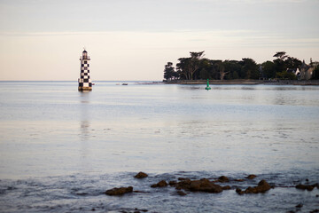 Sunset view of the Perdrix lighthouse in front of Ile-Tudy, Finistere, Brittany, France.