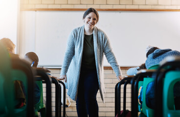 Happy woman, portrait and teacher with school kids for classroom assessment, test or exam. Female person, invigilator or educator with smile for childhood development, growth or knowledge in class