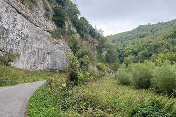 Quiet road in the mountains of the Peak District filled with lots of green nature.