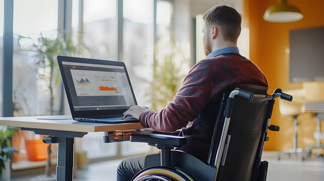 Remote working. a disabled person with a physical disability in a wheelchair working on a computer with adaptive equipment