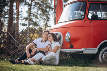 Beautiful happy couple in love man and woman, at the red bus trailer