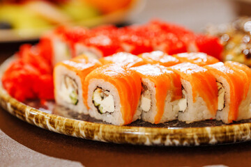 A large plate with rolls. A set of assorted rolls for the holiday. Ordering and delivery of Japanese cuisine.