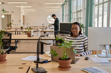 Focused young African businesswoman working at her desk in an office