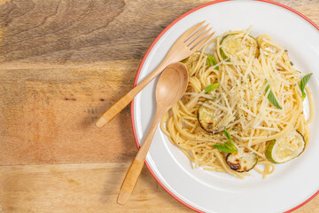 Plate of spaghetti with grilled zucchini and parmesan cheese.