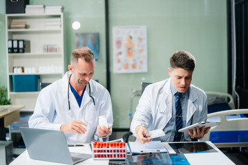 Obraz premium Diverse team of doctors and specialists brainstorming with digital tools, discussing test results and planning in hospital