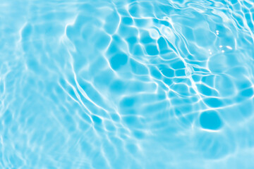 Blue water with ripples on the surface. Defocus blurred transparent blue colored clear calm water surface texture with splashes and bubbles. Water waves with shining pattern texture background.