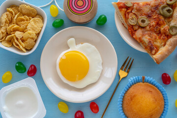 Breakfast ideas for kids. Sunny side up egg in the form of apple on the table with tasty and healthy food for kid's breakfast.