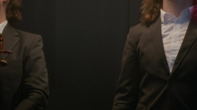 Aerial shot of Caucasian male and female string quartet bowing to audience after stage performance