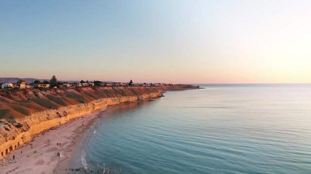 Aerial view of cliffs and beach at sunset over the ocean, Port Willunga, Australia.