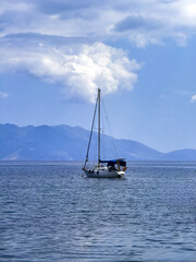 Obraz premium Sailing boat navigate on rippled sea, blue sky background