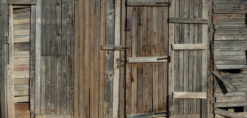 Home wall and door made from old worn wood, planks and rusty nails, grunge wooden background,