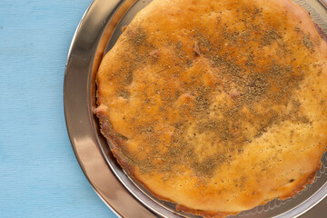 Moroccan Semolina Bread with zaatar on traditional tray. Top view.
