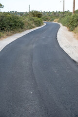Winding road ahead. New fresh asphalt layer on an empty street