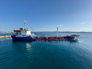 Fototapeta premium Industrial sea transportation, cargo ship moored at harbor Spetses island, Greece