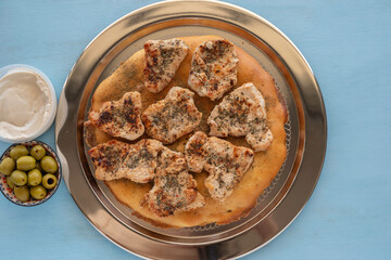 Green olives, roasted chicken chops over Moroccan bread chapati.