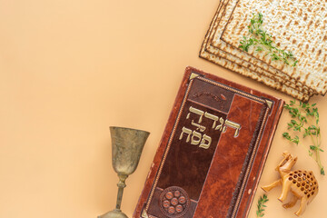 Jewish holiday Pesach celebration concept. Traditional book with text in Hebrew: 