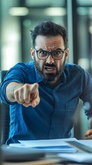 Obraz premium An angry boss in an office, pointing at the camera with his finger, sitting behind a desk and holding papers