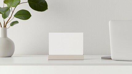 A clean, simple business card mock-up displayed in a holder on a minimalist desk