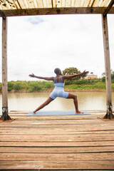 A beautiful young black woman practicing yoga outdoors in the countryside