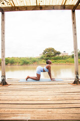 A beautiful young black woman practicing yoga outdoors in the countryside