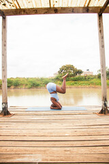 A beautiful young black woman practicing yoga outdoors in the countryside
