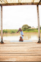 A beautiful young black woman practicing yoga outdoors in the countryside