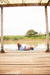 A beautiful young black woman practicing yoga outdoors in the countryside