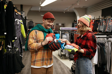 Young man and woman shopping sports gear for bicycle tour in winter