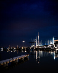 A nighttime scene of a dock with yachts