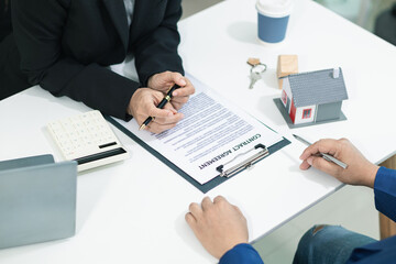 Fototapeta premium Real estate agent is talking to customer to present promotion for signing contract buy and selling real estate in company project in real estate office. present promotion to make customer decide buy.