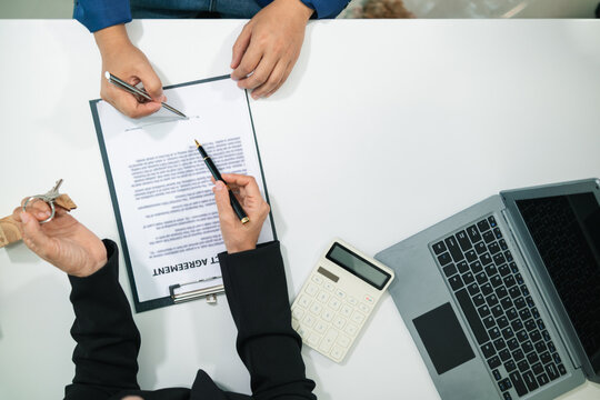 Real estate agent is talking to customer to present promotion for signing contract buy and selling real estate in company project in real estate office. present promotion to make customer decide buy.