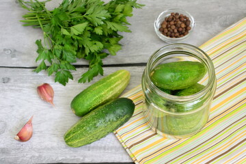 a jar of cucumber next to some other vegetables preserving for winter