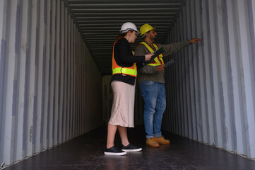 A group of men and women of professional container assemblers stand in a container shipping yard, looking at the preparation of containers. Logistics workers working at containers