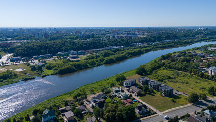 Drone photography of a city surrounded by nature and river during summer day