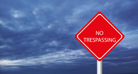 No trespassing sign on sky background
