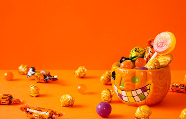 Halloween’s cup filled with Halloween treats. ハロウィンのお菓子でいっぱいになったハロウィン用のカップ