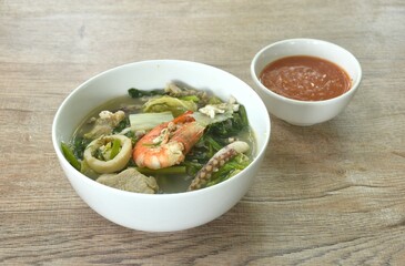 boiled sukiyaki seafood chicken and pork meat couple crispy pickled squid and shrimp with vegetable in soup on bowl dipping sauce