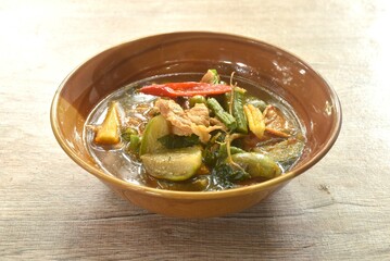 spicy boiled pork with mixed vegetable in jungle curry soup Thai food in bowl