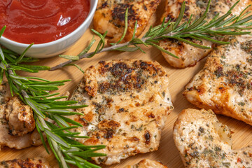 Turkey chops, fresh rosemary, tomato sauce for barbecue over wooden background.